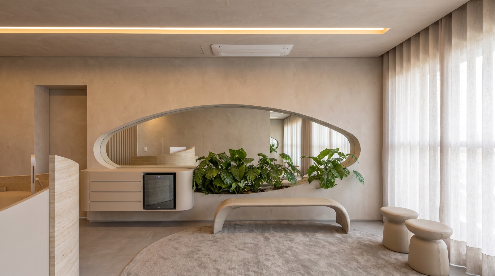 Recepção da Clinique Léman com espelho orgânico, jardim interno e mobiliário curvo